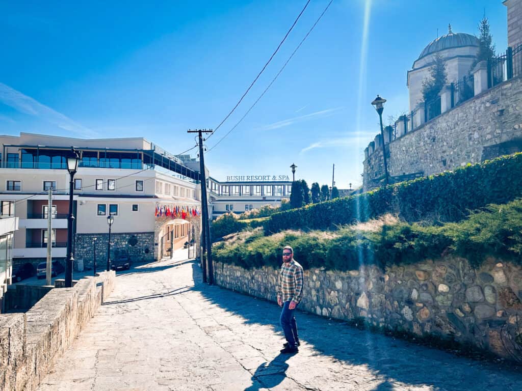 Wes standing on stone road in front of Bushi Resort and Spa with Blue Mosque in the background